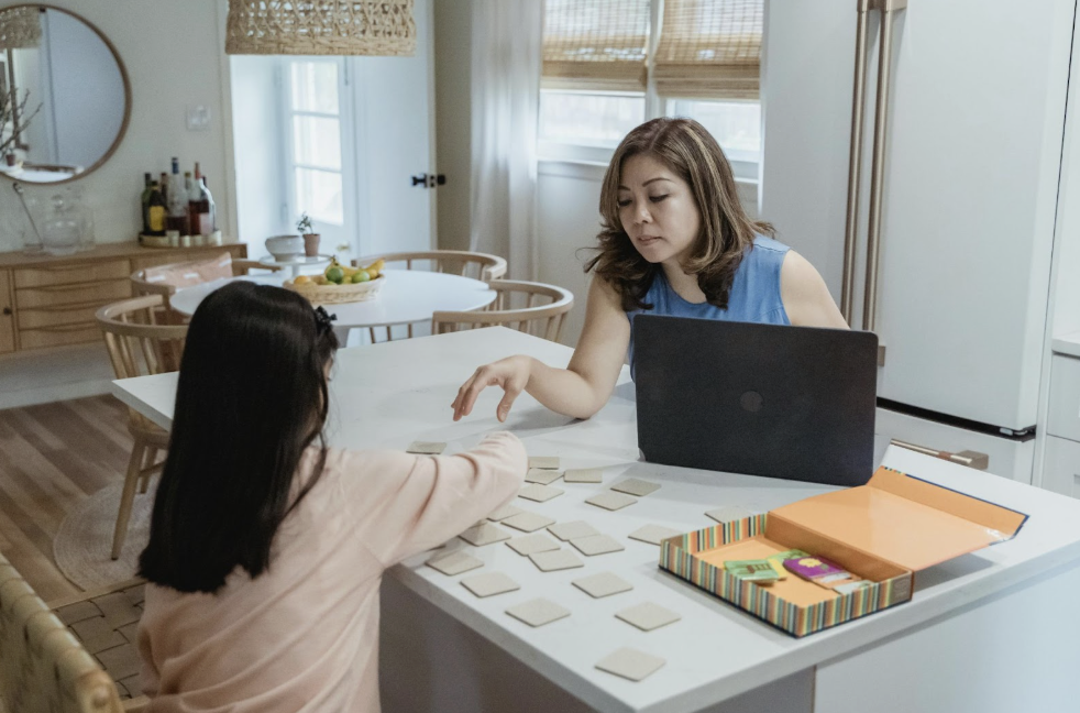 Mother teaching her daughter to read with help of multiple cards 